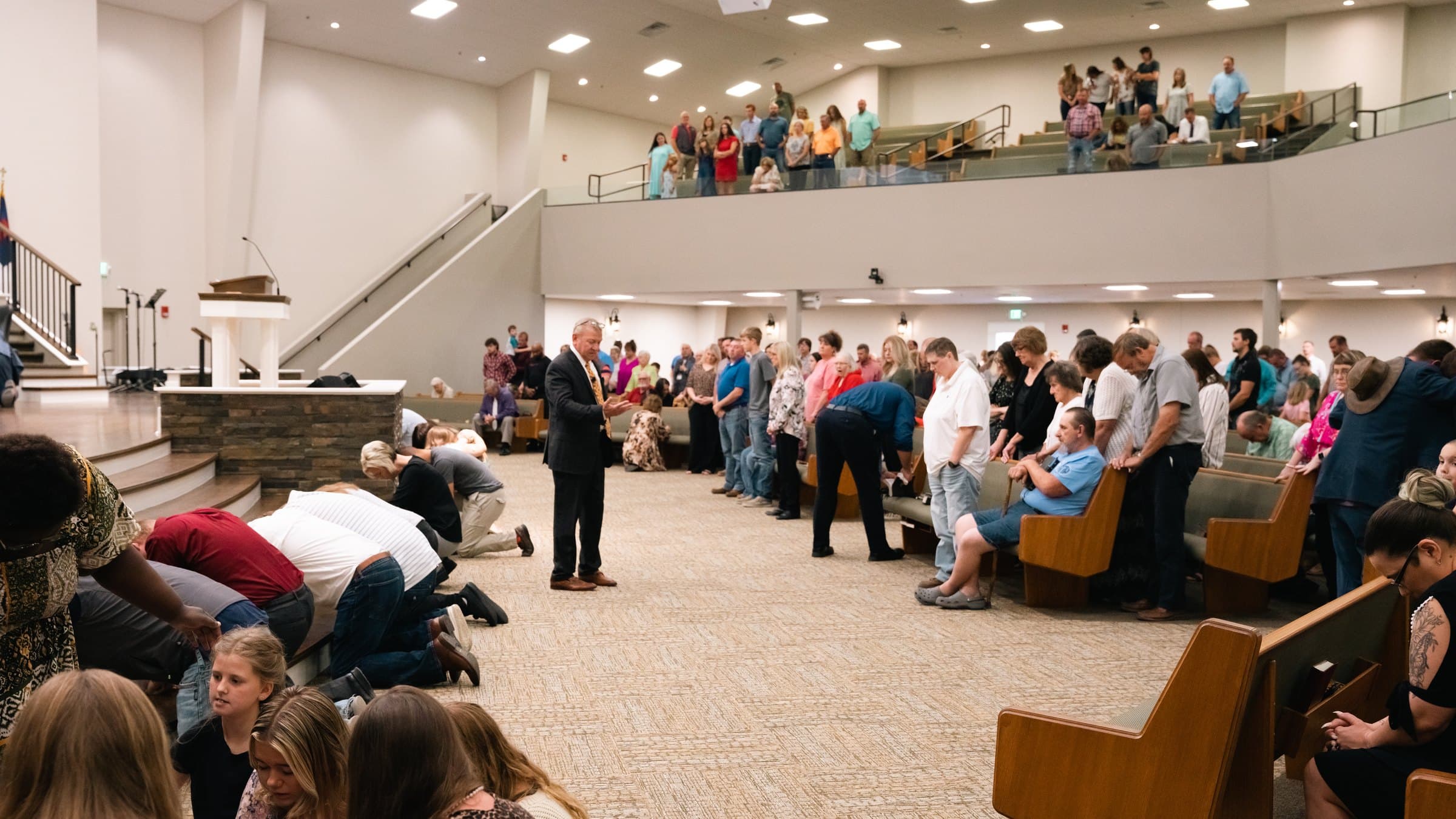 People kneeling at the altar in prayer during a service at Maple Springs